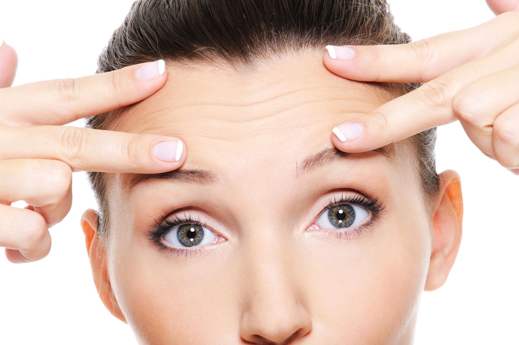 A woman's hands placed on her forehead.